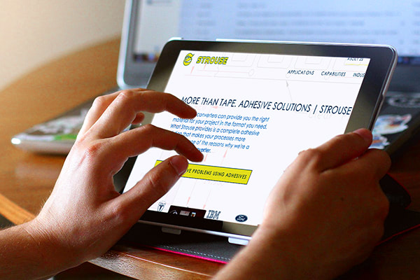 Person using a tablet to view the Strouse website