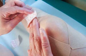 applying_adhesive_bandage_to_knee
