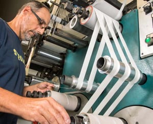 person-working-foam-tape-machine